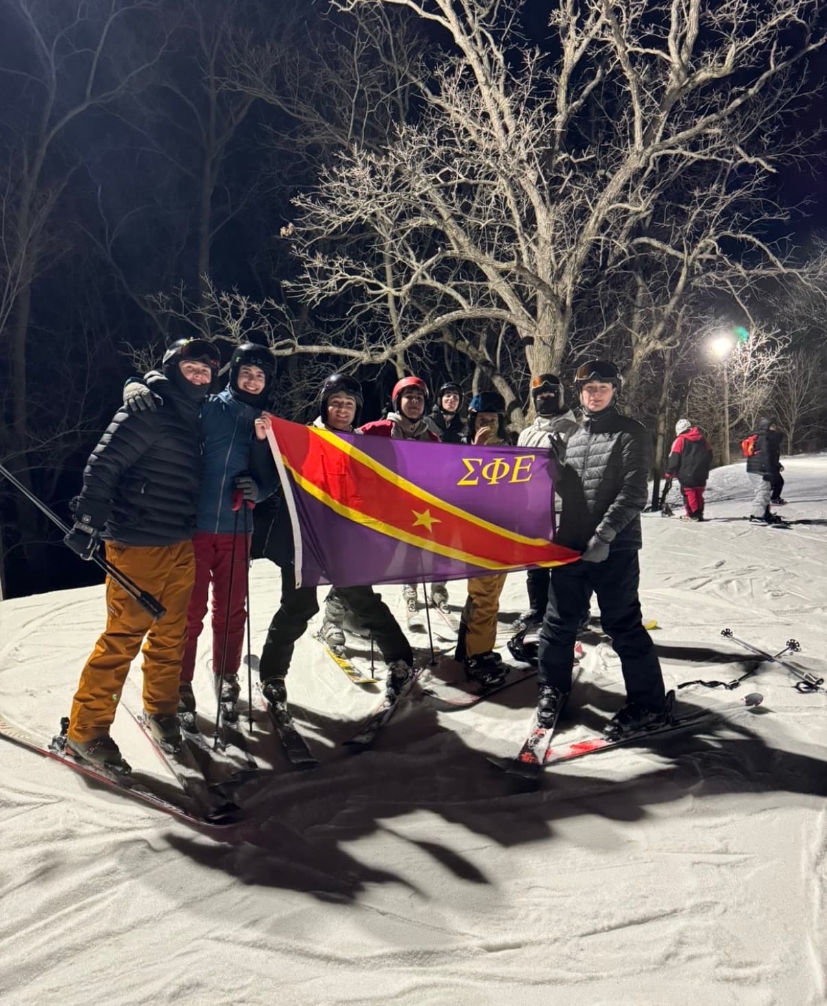 Brothers skiing with the SigEp flag